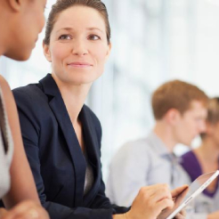 Femeie de afaceri care folosește o tableta digitala in intălnire